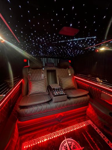 Luxury limousine interior with leather seats and ambient lighting.