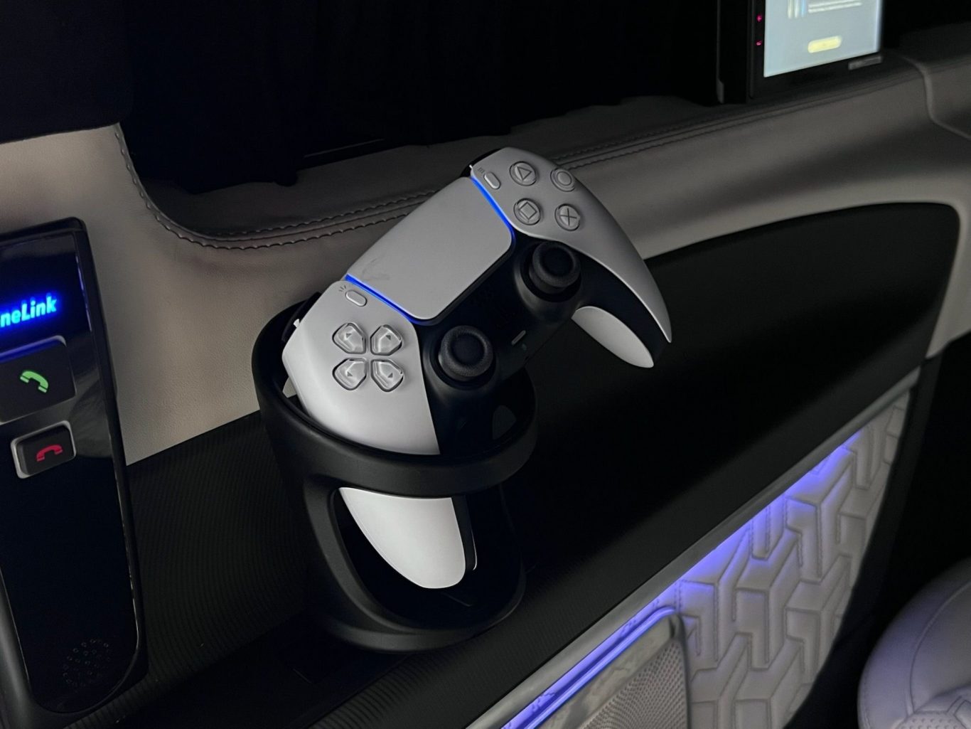 White PlayStation 5 controller resting in a holder on a sleek console.
